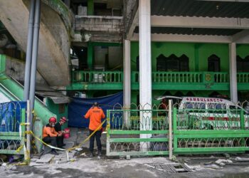 PASUKAN penyelamat berehat sementara operasi diteruskan di lokasi runtuhan bangunan di pondok pengajian Al Khoziny, Sidoarjo, Jawa Timur, kelmarin.- AFP