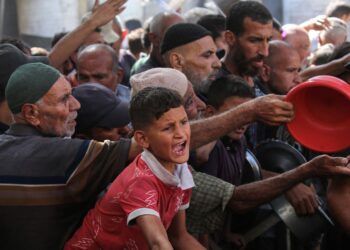 SEORANG kanak-kanak Palestin berkumpul untuk mendapatkan makanan dari dapur amal di kem pelarian Nuseirat, di tengah Gaza, dua hari selepas gencatan senjata berkuat kuasa. – AFP