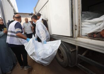 PEKERJA bilik mayat mengangkat jenazah rakyat Palestin yang diserahkan oleh Israel daripada kenderaan Bulan Sabit Merah ke Hospital Nasser di Khan Younis, selatan Gaza.- AFP