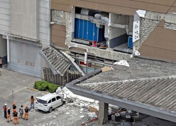 PIHAK berkuasa memeriksa bangunan rosak di luar sebuah pusat beli-belah di Bandar Butuan, di pulau selatan Mindanao, selepas gempa bumi 7.4 magnitud landa Filipina semalam.- AFP