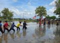 PESERTA Temasya Orang Kampung PDM Sungai Berembang mengambil bahagian dalam acara tarik tali dalam sawah yang dianjurkan di Kampung Behor Tui, Perlis.-UTUSAN
