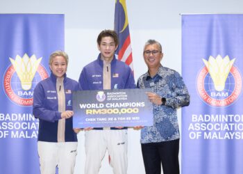 Menteri Pelaburan, Perdagangan dan Industri yang juga Presiden Persatuan Badminton (BAM), Tengku Datuk Seri Zafrul Tengku Abdul Aziz (kanan) menyerahkan mock cek hadiah kepada Beregu campuran kebangsaan, Chen Tang Jie-Toh Ee Wei pada Majlis Insentif Pemenang Pingat Kejohanan Badminton Dunia 2025 di Petronas Akademi Badminton Malaysia di sini hari ini. - UTUSAN/FARIZ RUSADIO