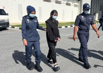 TERTUDUH (dua dari kiri) dibawa keluar dari Kompleks Mahkamah Kangar, Perlis, selepas berdepan pertuduhan mengedar dadah jenis ganja semasa memasuki negara ini melalui sempadan Padang Besar pada 8 Oktober lalu.-UTUSAN/ASYRAF MUHAMMAD