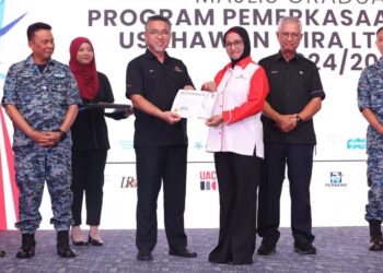 ADLY Zahari (tengah) menyampaikan sijil kepada salah seorang graduan pada Majlis Graduasi dan Pelancaran Program Pemerkasaan Usahawan Wira LTAT di Pangkalan Udara Butterworth, Pulau Pinang, semalam. – UTUSAN/SITI NUR MAS ERAH AMRAN