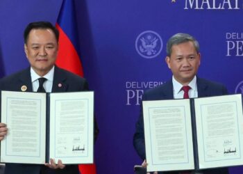 ANUTIN Charnvirakul (kiri) dan Hun Manet menunjukkan perjanjian damai bersama yang ditandatangani di Kuala Lumpur semalam. 