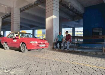 DUA sahabat, En Abdullah (kiri), 74, dan Amir Hamzah (kanan), 70, bersembang sambil menunggu pelanggan yang semakin berkurangan di Kompleks Terminal Bas dan Teksi, Kangar, Perlis semalam.
– UTUSAN/IZLIZAN OTHMAN