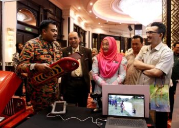 NOR Yahati Awang dan Mohd. Hisyam Mohd. Anip (kanan) diberi penerangan mengenai pelampung menyelamat selepas Forum Iklim Kebangsaan dan Kesiapsiagaan Bencana di Kota Bharu, Kelantan semalam.-UTUSAN/KAMARUL BISMI KAMARUZAMAN.