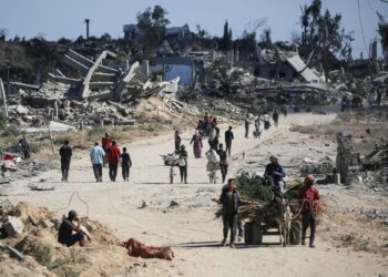 penduduk Palestin berjalan pulang ke rumah masing-masing yang telah ranap dibedil tentera Israel di kawasan al-Zahra, Gaza, semalam. –AFP