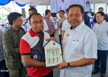 ABDUL Rahman Mohamad (kanan) menyampaikan kunci Rumah Makmur Kuala Lanar, Lipis Pahang. - MINGGUAN/ SALEHUDIN MAT RASAD