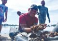 ZUHAIZDI Ibrahim dari Sungai Udang menunjukkan hasil kutipan kerang di Pantai Klebang, Melaka semalam. – MINGGUAN/AMRAN ALI