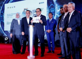 Mohamed Khaled Nordin menunjukkan buku Pelan Transformasi PERHEBAT selepas majlis peluncuran pelan tersebut di Kuala Lumpur, semalam. – UTUSAN/SHIDDIEQIIN ZON