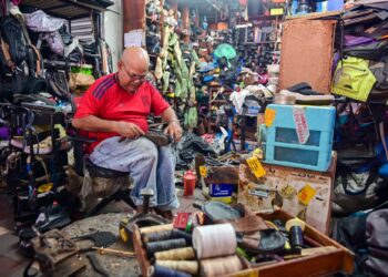 SAIDI Mohd. membaiki kasut-kasut yang dihantar pelanggannya di Kompleks Hentian Bandaraya Kuala Terengganu (MBKT), Terengganu. – UTUSAN/PUQTRA HAIRRY