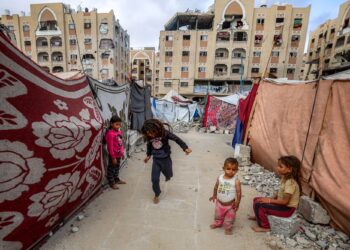 Kanak-kanak bermain-main di luar khemah pelarian perang yang dibina oleh kerajaan Qatar di kawasan penempatan Bandar Hamad yang musnah di selatan Gaza, Palestin. – AFP