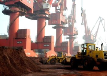 PEKERJA mengangkut tanah yang mengandungi unsur nadir bumi untuk dieksport di sebuah pelabuhan di Lianyungang di wilayah Jiangsu, China.-AFP