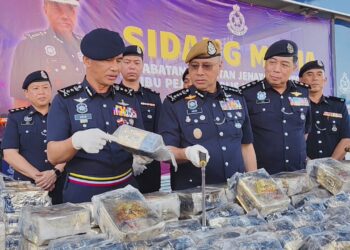 NOOR Hisam Nordin (tengah) menunjukkan dadah yang dirampas dalam sebuah MPV yang ditinggalkan dua lelaki di Lebuh Raya Utara-Selatan arah selatan dekat Slim River, Isnin lalu. - UTUSAN