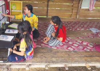 Lorenica Frenila Masundim  menunjukkan cara menggunakan alat bantu belajar yang ditampal di sudut belajar yang dibinanya bersama murid di rumah  murid berkenaan di Kg. Koiboton, Paitan, Beluran, Sabah.