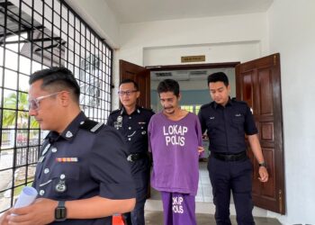 ROSDI Muhamad (tengah) diiringi polis semasa menghadiri prosiding perbicaraan di Mahkaman Sesyen Gua Musang, Kelantan. - UTUSAN/ AIMUNI TUAN LAH.