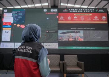 NUR Adibah Razali melihat skrin laman web penjejak Sumud Nusantara Flotilla di SNCC, Sepang. - UTUSAN/FAIZ ALIF ZUBIR