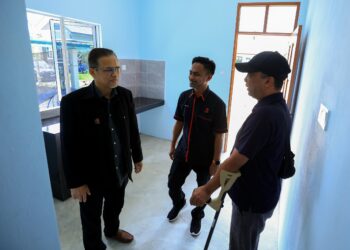 AZMAN Ismail (kiri) melihat keadaan rumah semasa Penyerahan Kunci Rumah Rahmah di Mukim Che Latiff, Pantai Mek Mas, Kota Bharu, Kelantan. - UTUSAN/KAMARUL BISMI KAMARUZAMAN