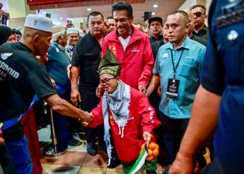 MUHAMMAD Abdullah dan Mohd. Asmawi Mukhtar bersalaman dengan orang ramai selepas tiba di Lapangan Terbang Sultan Mahmud (LTSM), Kuala Nerus, Terengganu. - UTUSAN/PUQTRA HAIRRY