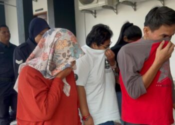 BAPA (depan, baju putih) dan ibu (kiri, tudung berbunga) kepada kanak-kanak yang cedera di leher dipercayai akibat dikelar dengan senjata tajam dibawa keluar dari Mahkamah Majistret Batu Pahat, hari ini.