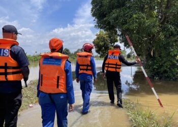 ANGGOTA polis dan Angkatan Pertahanan Awam (APM) memantau keadaan semasa banjir di Kampung Alor Ali, Pendang. - UTUSAN/ SHAHIR NOORDIN