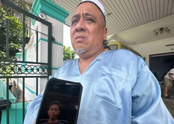 KAMARUL HAFIZ Jaafar menunjukkan gambar arwah anak bongsunya, Muhammad Darwish yang maut dalam kemalangan di Kilometer 32.5, Jalan Muar-Segamat, Tangkak, malam semalam.