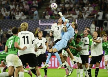 Penjaga gol Jerman, Oliver Baumann menumbuk bola keluar dari kawasan bahaya selepas diasak jentera serangan Ireland Utara dalam kelayakan Piala Dunia 2026 di Cologne, semalam. - AFP