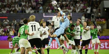 Penjaga gol Jerman, Oliver Baumann menumbuk bola keluar dari kawasan bahaya selepas diasak jentera serangan Ireland Utara dalam kelayakan Piala Dunia 2026 di Cologne, semalam. - AFP