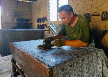 MOHD. Fuad Musa melakukan kerja-kerja mengecop batik di sebuah bengkel batik di Kampung Seberang Takir di Kuala Nerus. Terengganu.
– UTUSAN/ERMA YUSNIDA JUSOH