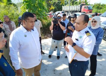 Muhamad Arafat Varisai Mahamad (kiri) mendengar penerangan daripada wakil Majlis Bandaraya Ipoh mengenai aduan penduduk berkenaan operasi kilang pasir di Ipoh, Perak semalam. – Utusan/FADZIL ZAINOL
