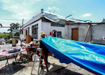 PENDUDUK membersihkan rumah yang terkesan akibat dilanda ribut di perumahan Jalan Manggis, Telok Panglima Garang, Selangor, minggu lalu.-UTUSAN/AFIQ RAZALI