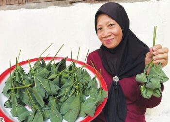 ROSNAH Ishak menunjukkan tapai pulut daun getah yang dihasilkannya di Kampung Tulang Rimau, Johol, Kuala Pilah. - UTUSAN/NOR SHAFIQAH MOHD. GHAZALI
