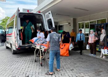 MOHAMAD Basri Ibrahim dibawa turun daripada ambulans untuk dibawa pulang ke Malaysia di lapangan terbang Bandar Raya Ho Chi Minh, Vietnam.-IHSAN KELUARGA