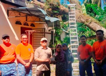 MOHD. Saufi Ibrahim (tiga dari kiri) menyampaikan sumbangan wang tunai kepada Zeton Ahmad di Sungai Megat Aris Bagan Tiang di Parit Buntar semalam. - UTUSAN/WAT KAMAL ABAS