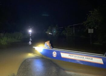 ANGGOTA Angkatan Pertahanan Awam Malaysia (APM) memantau keadaan banjir di Kampung Bangkulat, Tongod, Sandakan, Sabah semalam. - IHSAN APM