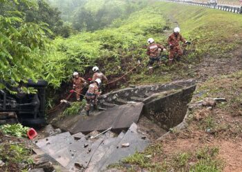 ANGGOTA bomba mengeluarkan mangsa dalam trak tentera yang terbabas dan terjunam ke dalam gaung di Kilometer 257, Lebuh Raya Utara-Selatan arah utara selepas Terowong Menora hari ini. - UTUSAN/IHSAN JBPM PERAK