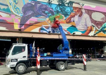 DHIYAUL Mohamad Ashraf Dawari sedang menyiapkan mural gergasi di Pasar Payang, Kuala Terengganu, Terengganu. – MINGGUAN/ERMA YUSNIDA JUSOH