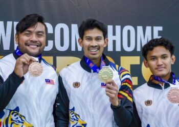 Abdul Latif Romly (tengah) bersama Muhammad Ziyad Zolkefli (kiri) dan Muhammad Nazmi Nasri menunjukkan pingat yang dimenangi mereka sejurus tiba di Lapangan Terbang Antarabangsa Kuala Lumpur (KLIA), Sepang, semalam. - UTUSAN/FAISOL MUSTAFA