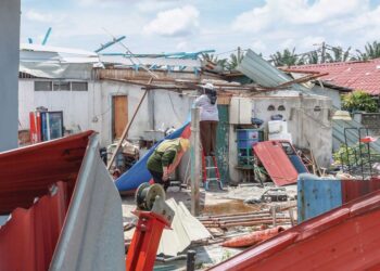 PENDUDUK giat membersihkan rumah yang terkesan akibat ribut dan puting beliung di
perumahan Jalan Manggis, Telok Panglima Garang, Selangor, semalam.-UTUSAN/AFIQ RAZALI