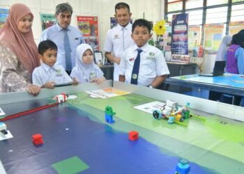 HAMZAN Hussein (tiga dari kiri) bersama Che Rasaidi Che Yob (dua dari kanan) meninjau inovasi dihasilkan oleh murid-murid di makmal robotik SK Tok’Ba, Kangar.
– UTUSAN/IZLIZAN OTHMAN