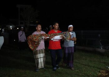 MUHAMMAD Badrul Rameli (tengah) bersama ahli keluarga membawa jenazah anaknya untuk dikebumikan di Tanah Perkuburan Islam Kampung Mujur, Jelawat, Bachok, Kelantan malam tadi-UTUSAN/KAMARUL BISMI KAMARUZAMAN.