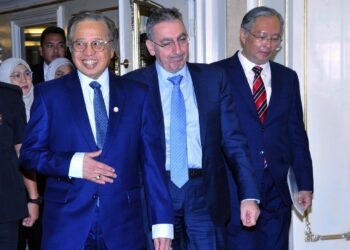 Abang Johari diiringi Zafer (tengah) dan Wan Lizozman (kanan) ketika tiba bagi menyaksikan upacara menandatangani RAS antara Kerajaan Sarawak, Kerajaan Persekutuan dan Bank Dunia di sebuah hotel terkemuka di Kuching, hari ini.