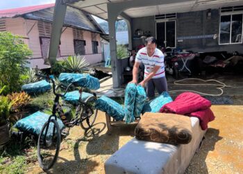NAZUAN Md Ali menjemur kusyen yang basah akibat hujan lebat selepas bumbung rumahnya di Kampung Solok Wan Moh rosak diterbangkan angin kencang petang kelmarin.
