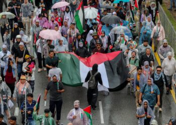 WALAUPUN dalam keadaan hujan, orang ramai tetap berarak menuju ke Kedutaan Amerika Syarikat ketika Himpunan Solidariti Sumud di Jalan Tun Razak, Kuala Lumpur semalam. – UTUSAN/FARIZ RUSADIO.
