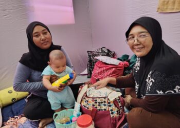 NORATIKA Hairolnizam ( kiri) memangku Arif Hakimi bersama ibunya, Noratikah Abd Aziz di PPS SK Melayu Raya, Pekan Nanas, Pontian.