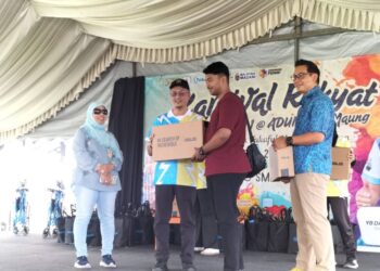MOHAMAD Abdul Hamid (kiri) menyampaikan bantuan sempena Karnival Rakyat bersama Timbalan Ketua Menteri-Siri Jelajah Takaful Masuk Kampung, di SMK Sungai Ara, Pulau Pinang, hari ini.