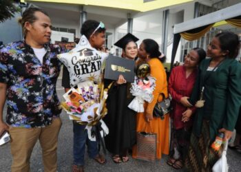 Cempaka Sari menerima ciuman tahniah dari ibunya sambil diperhatikan adik beradiknya selepas menerima diploma sistem komputer sempena Konvokesyen  Kolej Yayasan Pelajaran Johor ke 26 di Dewan Besar YPJ, Kota Tinggi, Johor kelmarin. UTUSAN/RAJA JAAFAR ALI
