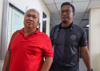 CHOO Kean Chee (kiri) diiringi oleh penguatkuasa JPN ketika hadir atas kesalahan memberi maklumat palsu ketika memohon kad pengenalan seorang kanak-kanak berusia 12 tahun pada Februari lalu, didakwa di Mahkamah Butterworth, Pulau Pinang.-UTUSAN/DANIAL SAAD