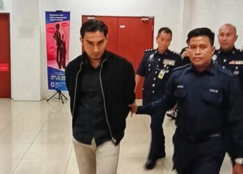 SHAZIFH Osman dan MUNIRA Hishamshah dibawa anggota polis ke Mahkamah Majistret Shah Alam, Selangor.-UTUSAN/ISKANDAR SHAH MOHAMED